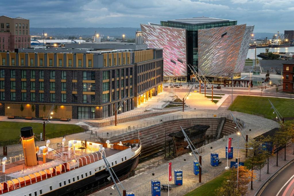 a large building with a train in front of it at Aloft by Marriott Belfast Titanic Quarter in Belfast