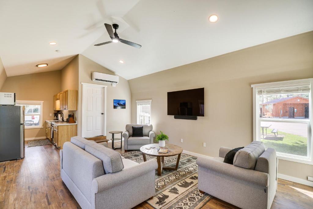 a living room with two chairs and a tv at Gateway to Glacier! 2-Cabin Compound for Groups in Columbia Falls