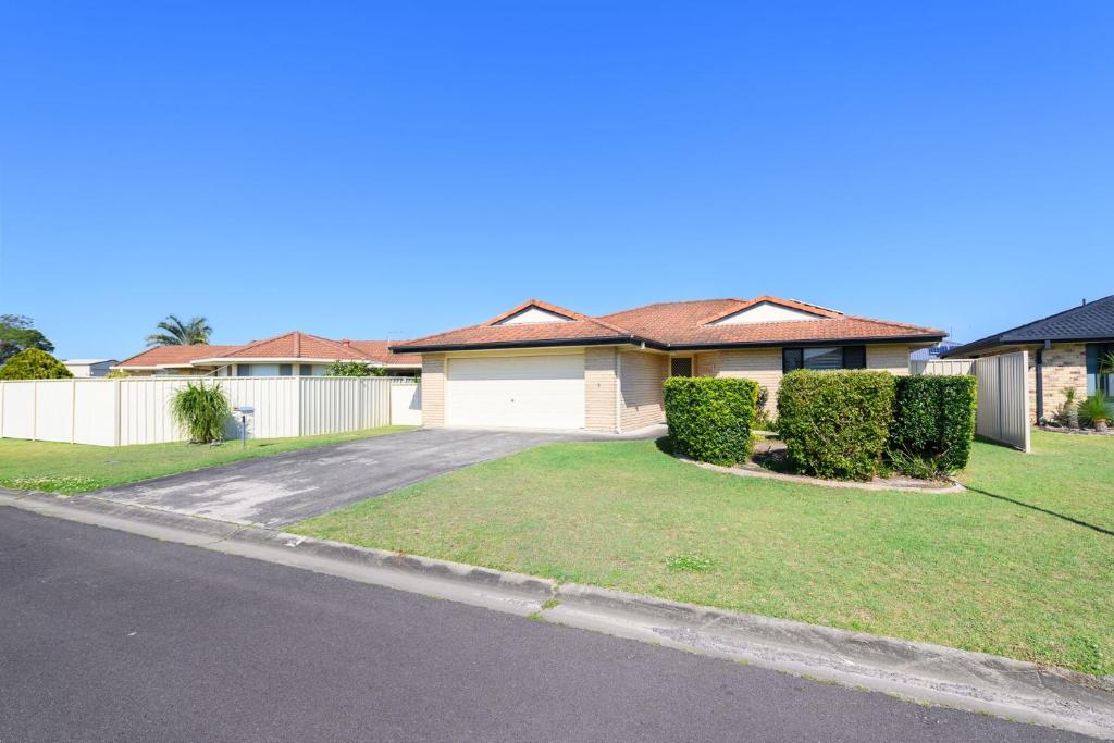 a house with a white fence and a driveway at Lomandra in Evans Head