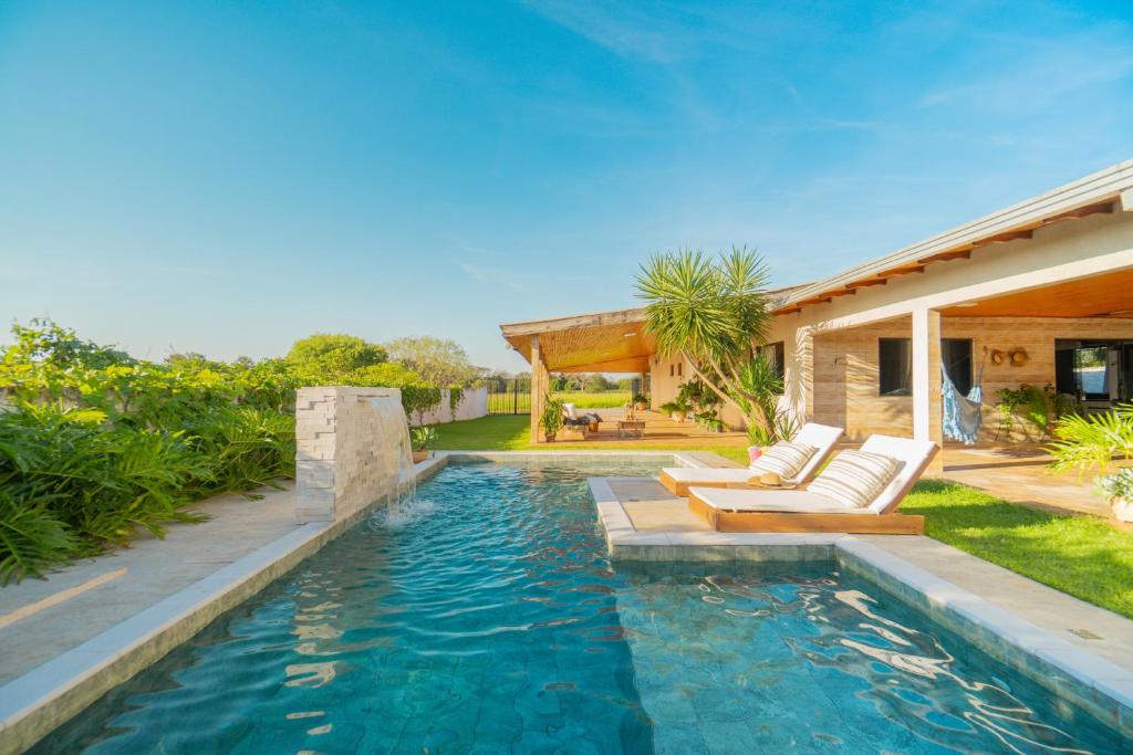 a swimming pool with two couches and a house at Casa de Campo Mimosa Flor Refugio Exclusivo Proximo Cataratas e Aeroporto IGU Piscina Privativa 12 Hóspedes in Foz do Iguaçu