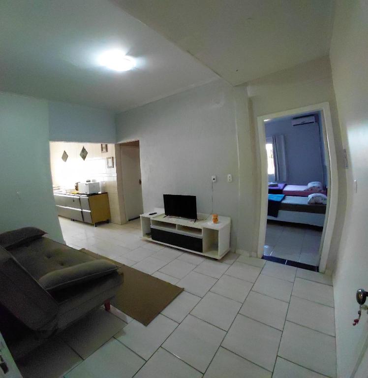 a living room with a couch and a laptop on a table at Pousada Familiar 10 in Rio do Sul