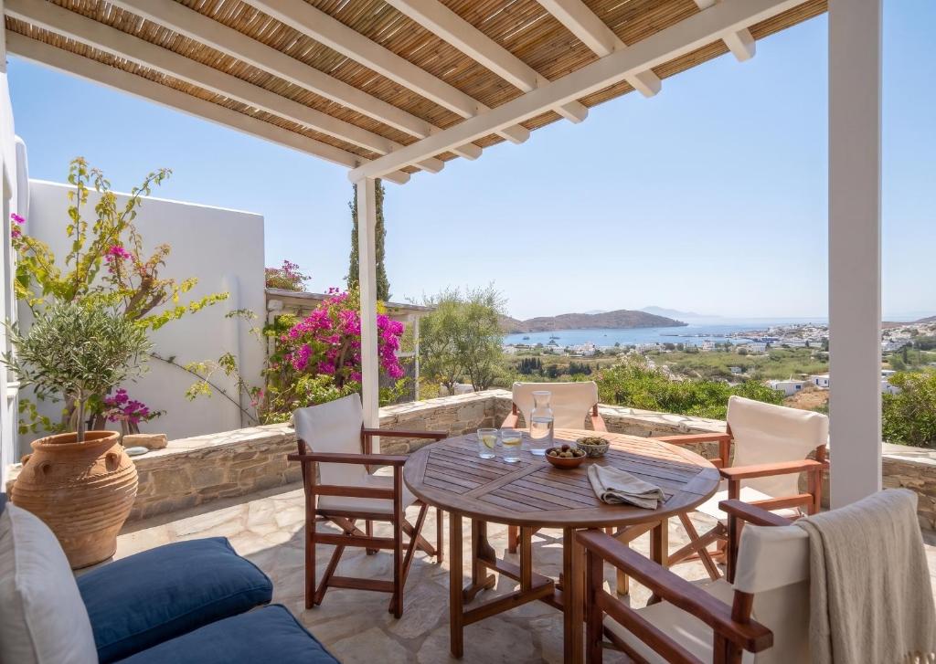 a patio with a table and chairs and a view of the ocean at Oneiro Serifos House in Serifos Chora