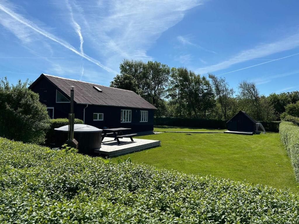 a black house with a picnic table and a tent at 6 person holiday home in Vinderup-By Traum in Vinderup