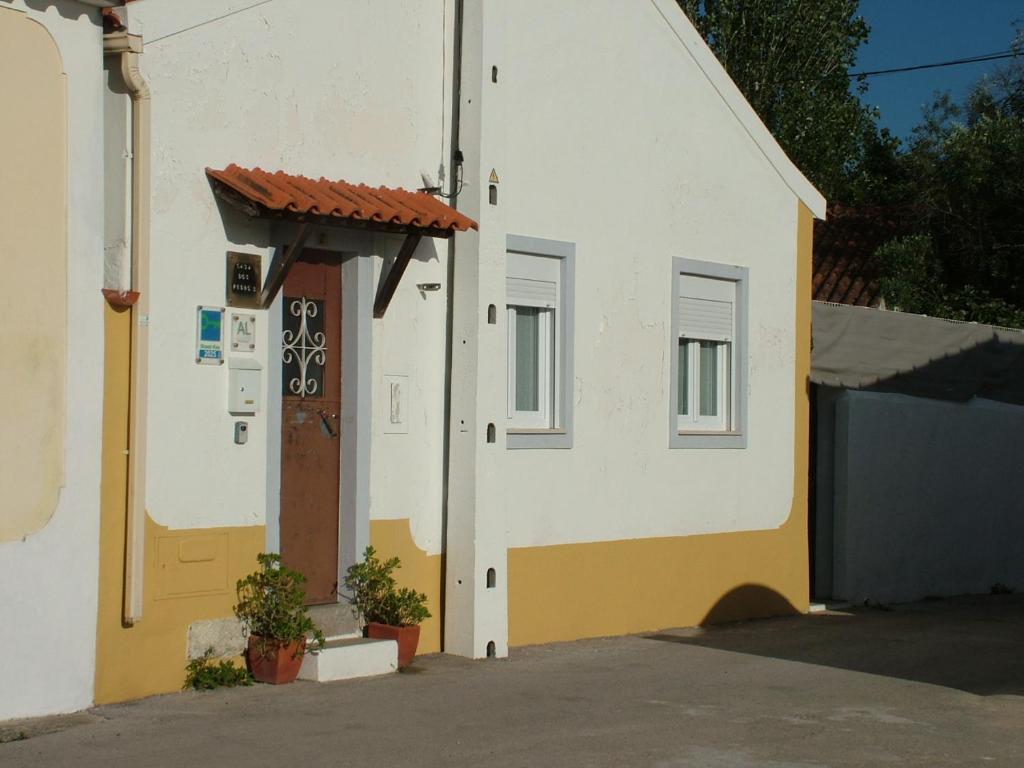 a white and yellow building with a door at Casa dos Pedro´s in Vila Nova