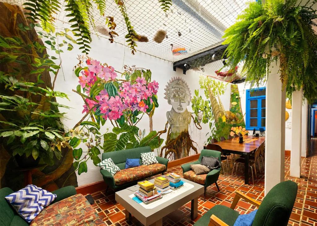 a living room with plants and a table at Granada Hostel in Bogotá