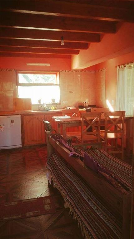a room with a table and a kitchen with a window at Cabañas Lago Guillelmo in San Carlos de Bariloche