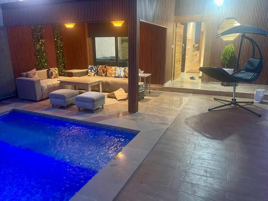 a living room with a couch and a swimming pool at Villa Moderne avec Piscine Privée in Imouzzer du Kandar