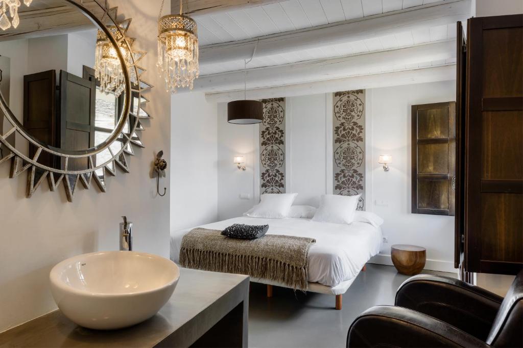 a bedroom with a bed and a sink and a mirror at Casas Pirineos in Sabiñánigo