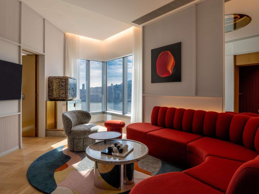 a living room with a red couch and a table at Mondrian Hong Kong in Hong Kong