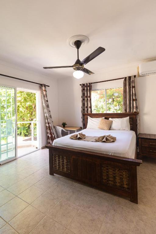 a bedroom with a bed with a ceiling fan at Yara Beach in Punta Cana