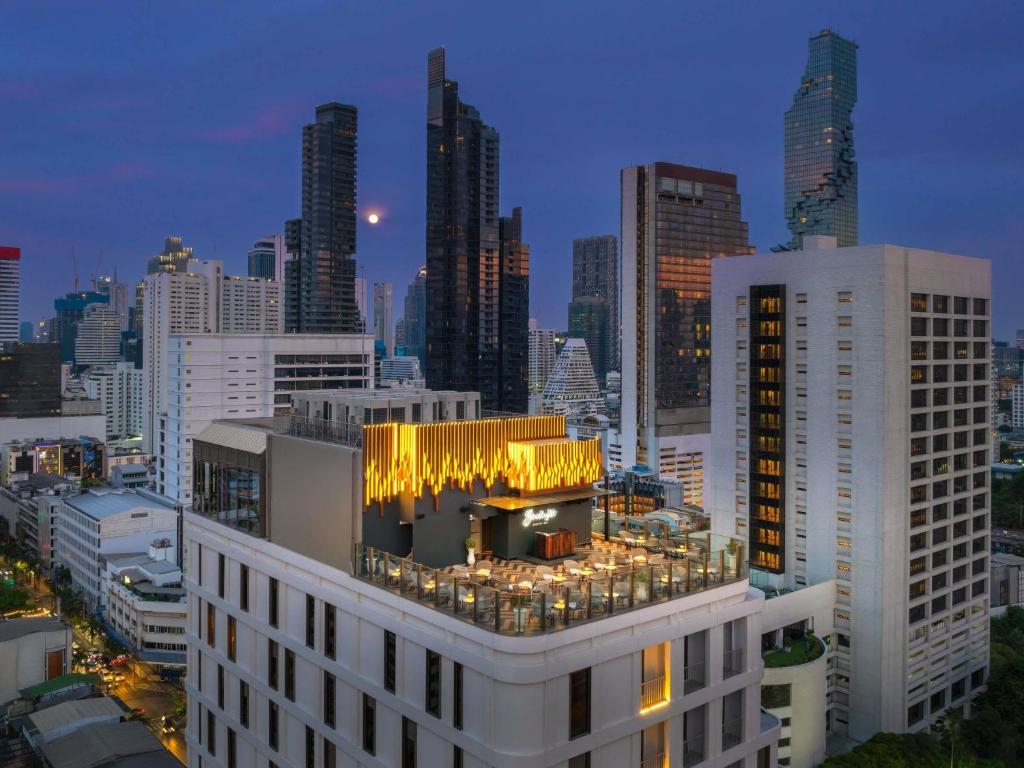 a view of a city skyline at night at Mercure Bangkok Surawong in Bangkok