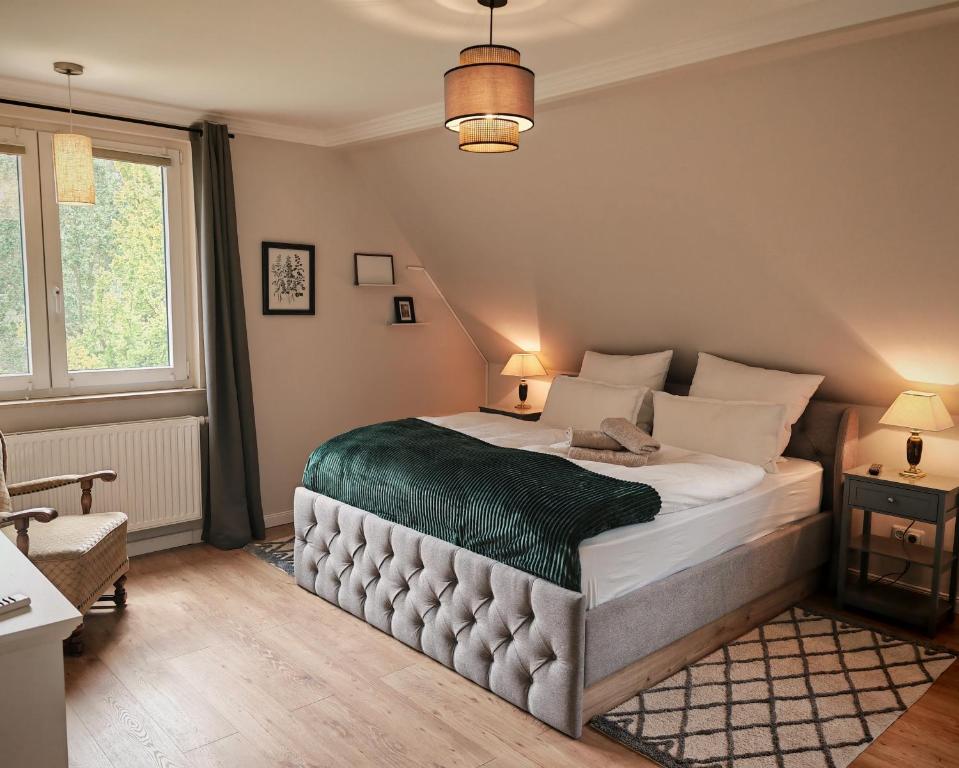 a bedroom with a bed with a green blanket at Green Lake House in Petershagen