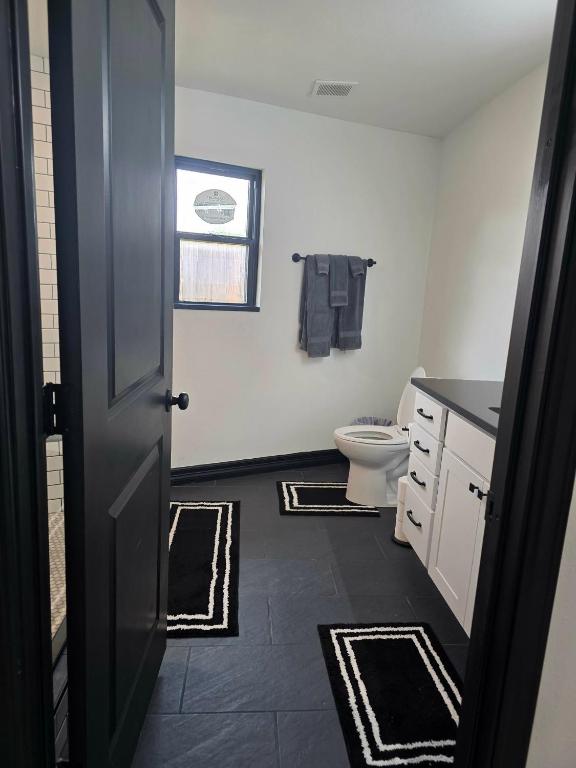 a white bathroom with a toilet and a door at Alma House in Corpus Christi