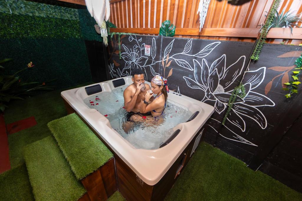 a man and woman sitting in a bath tub at Hormiga's Houses La Fortuna in Fortuna