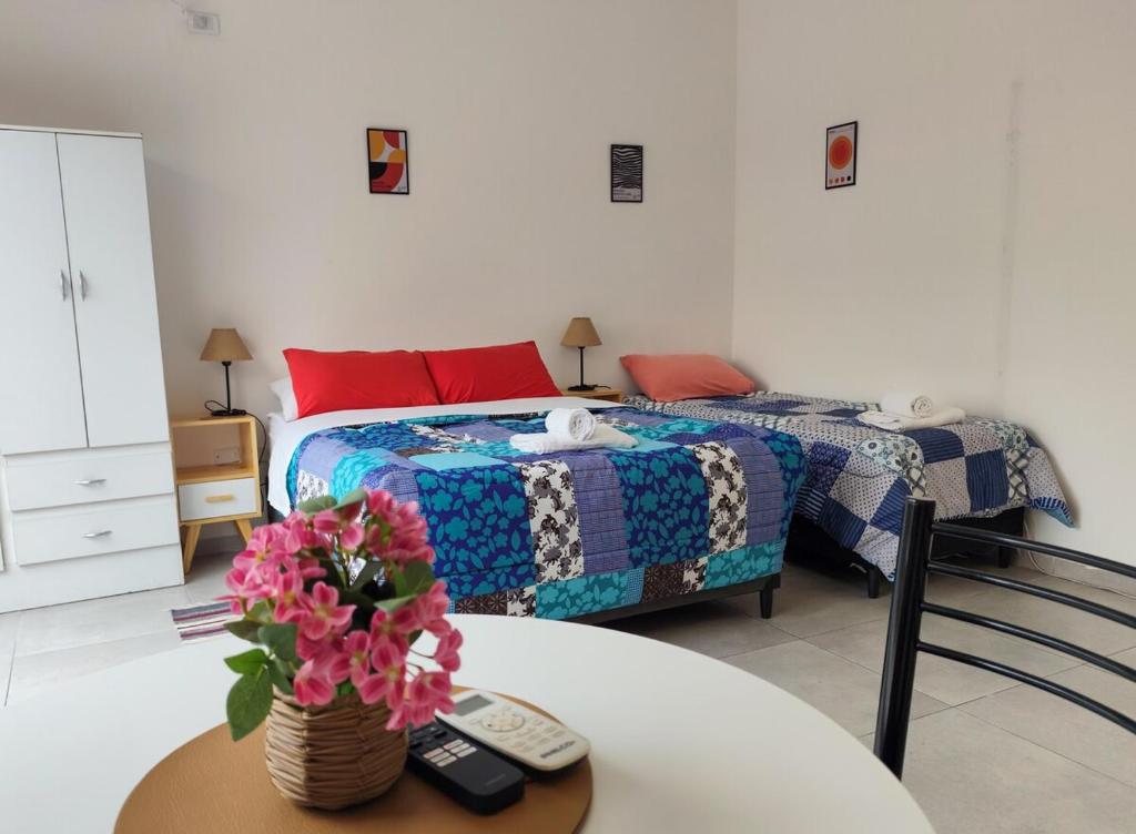 a bedroom with two beds and a table with flowers at Casa Arpy in Mendoza