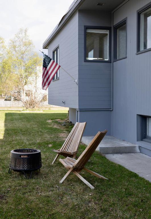 a couple of chairs and a grill in front of a house at Alaskan Hideaway | Cozy & Adventure-Ready in Anchorage
