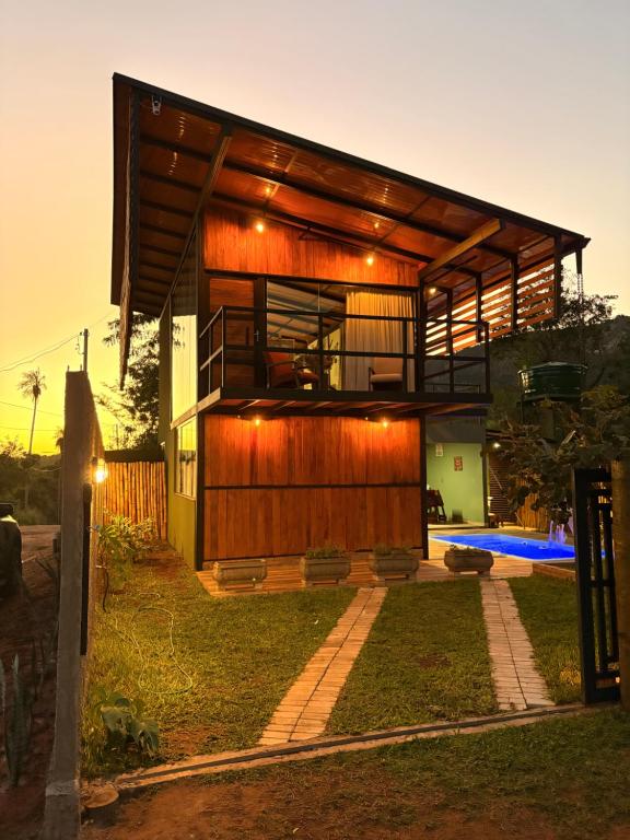 a house with a wooden facade with lights on it at Villa Iñaru hospedaria in Aquidauana