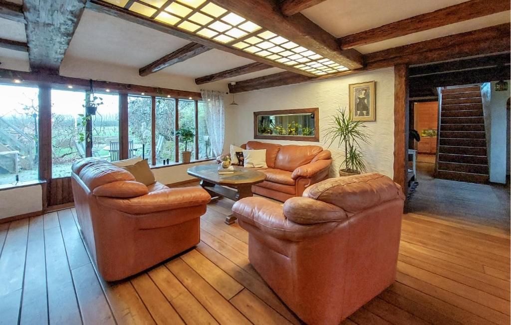 a living room with leather furniture and a table at Villa Kalle in Åstorp