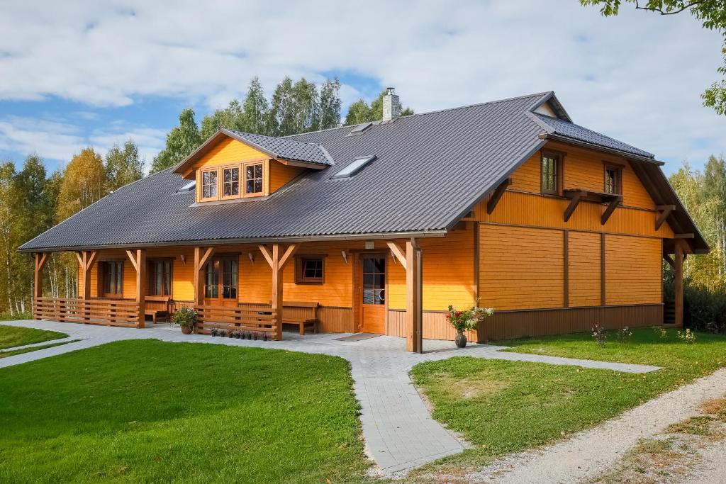 a large wooden house with a black roof at Paegli Guest house in Kaijciems