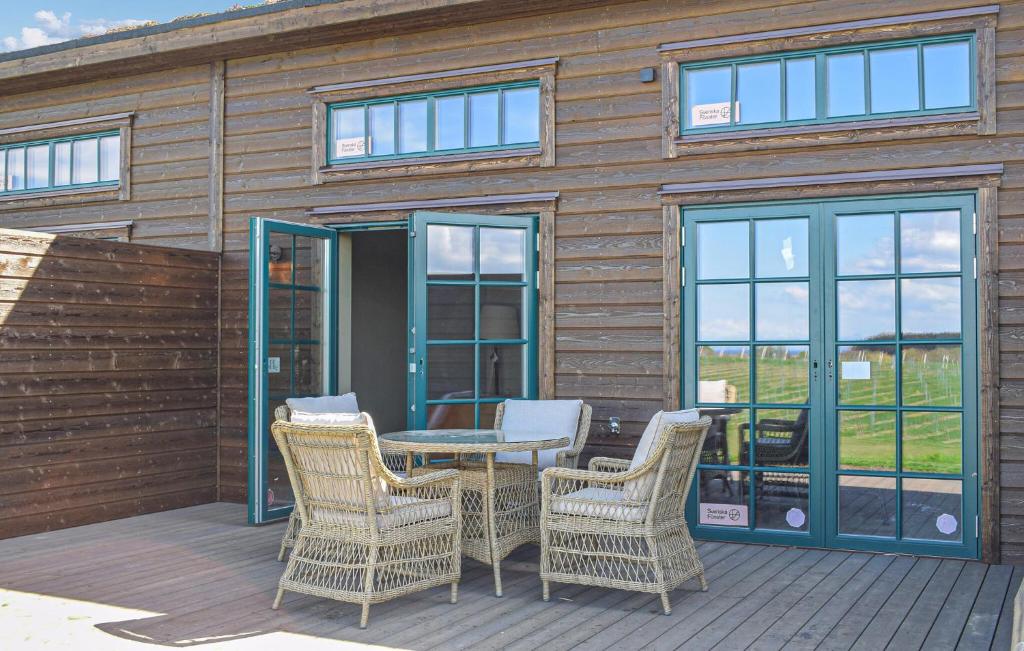 a cabin with a table and chairs on a deck at Beautiful Home In Kivik in Kivik
