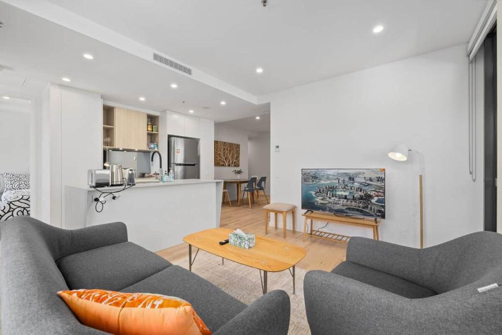 a living room with two couches and a table at Central 2b2b with 2 Parkings across largest Mall in Braddon