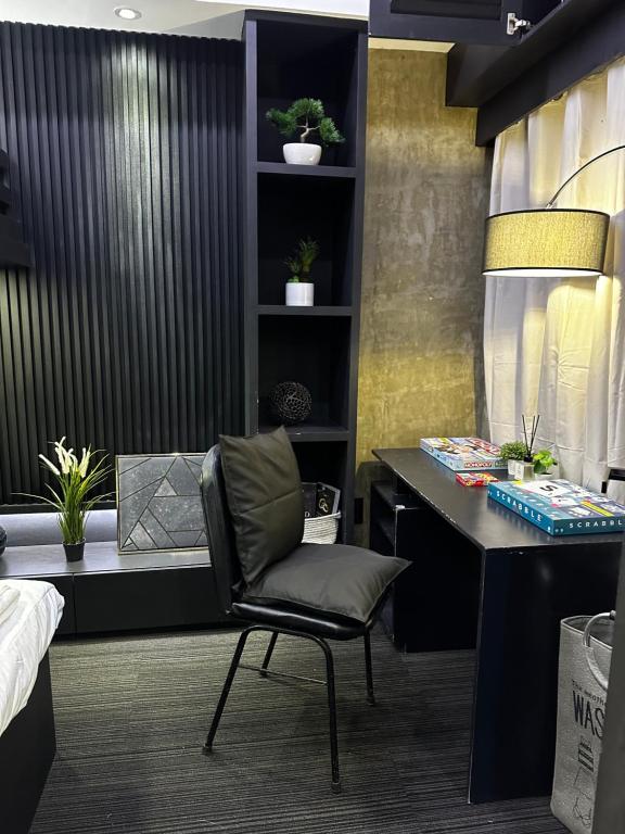 a desk and a chair in a room at Cloud & Rey condo rentals in Roxas City