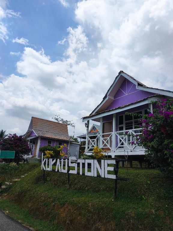 a house with a sign in front of it at Kurau Stone Chalet in Taiping