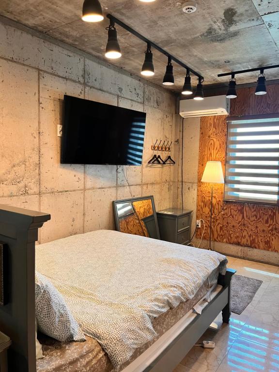 ein Schlafzimmer mit Bett und Flachbildfernseher in der Unterkunft 수스테이 펜션 in Seogwipo