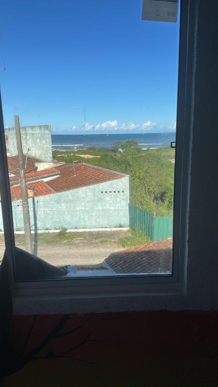 a window with a view of the ocean at Pousada Encanto De Itanhaém in Itanhaém