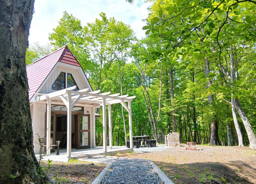 a small cabin in the woods with a tree at TID TID Yamanakako in Yamanakako