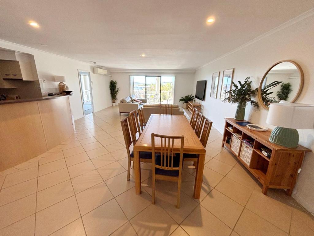 a dining room and kitchen with a table and chairs at Jubilee Apartment 06 in South West Rocks