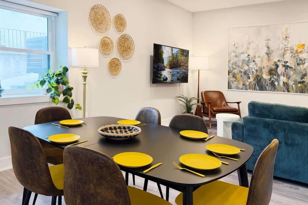 a dining room with a black table and yellow chairs at 1500 Sq ft Space 2 Bed 2 Bath Large Kitchen in Conshohocken