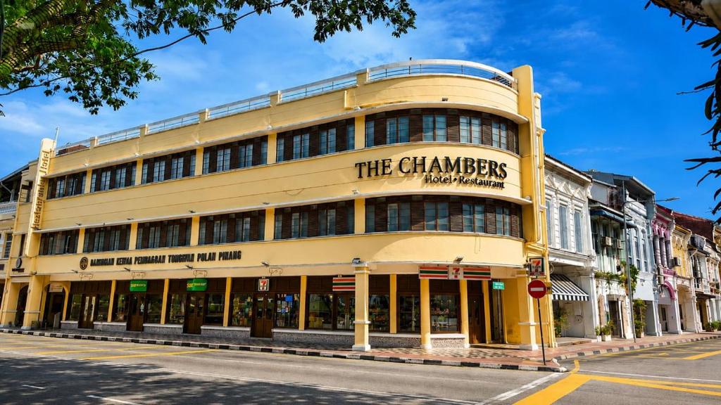 a yellow building with a sign on it on a street at The Chambers Georgetown in George Town