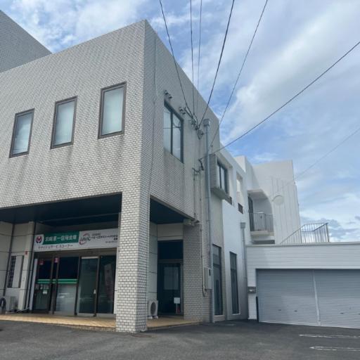 a brick building with a garage in front of it at Lemon みやざき in Miyazaki