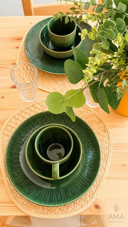 a table with green plates on a wooden table at Comfortable Central Apartment in Santo Domingo