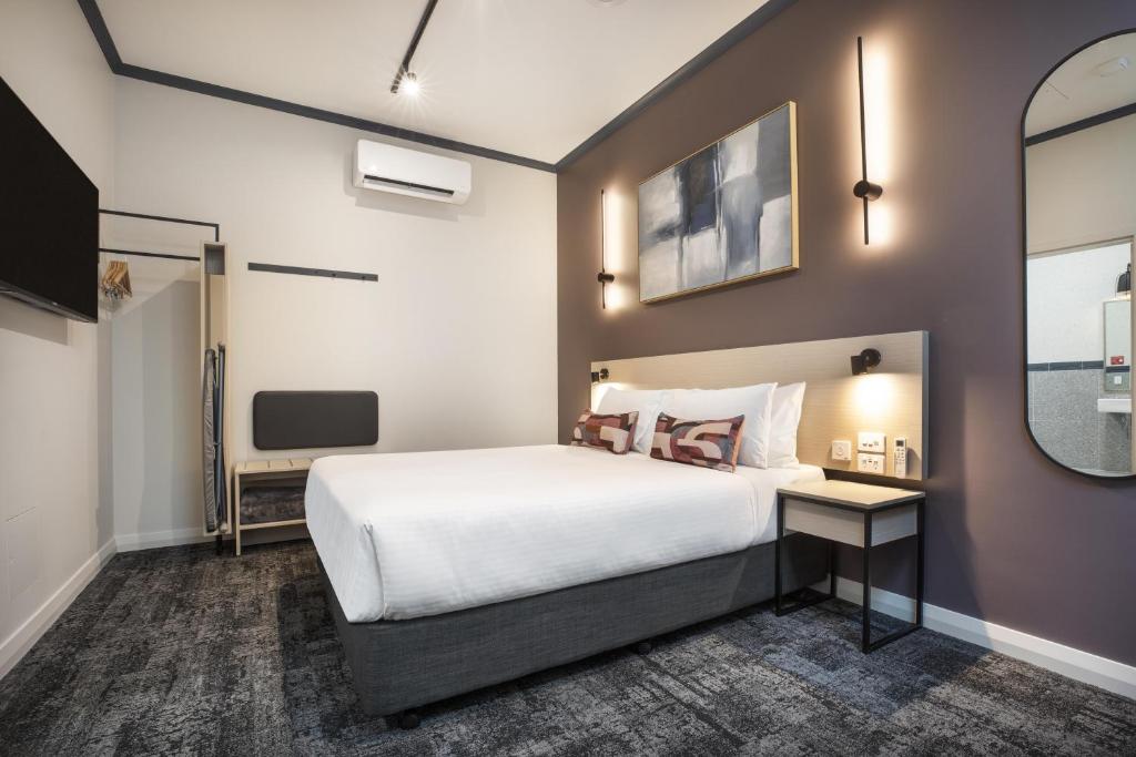 a hotel room with a bed and a tv at Nightcap at Wanneroo Tavern in Wanneru