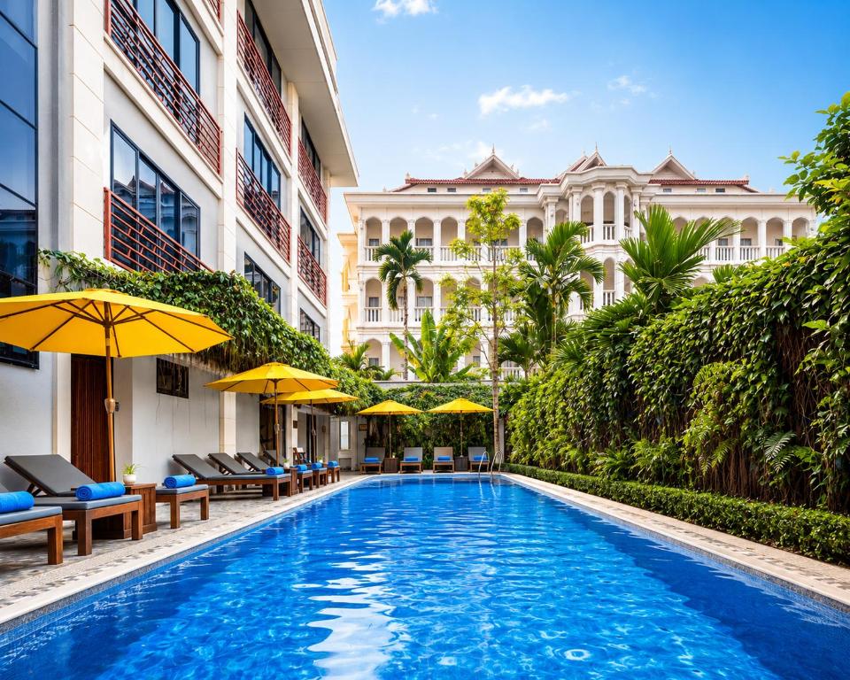 a swimming pool with chairs and umbrellas next to a building at Angkor Mansion & Residence in Siem Reap