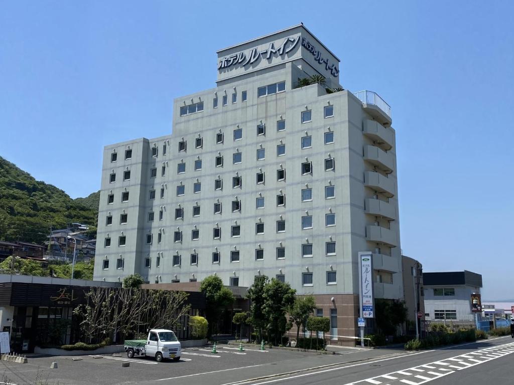 a white building with a car parked in front of it at Hotel Route-Inn Mojiko in Kitakyushu