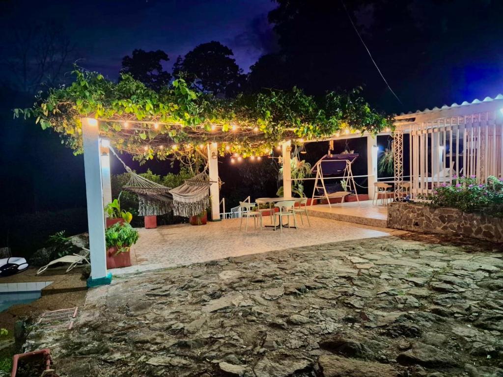a patio with a pergola at night at Villa Nacha in Villeta
