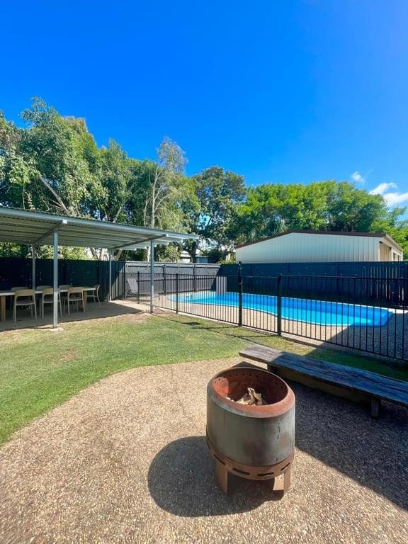 a fire pit next to a bench and a fence at Iluka in Yeppoon