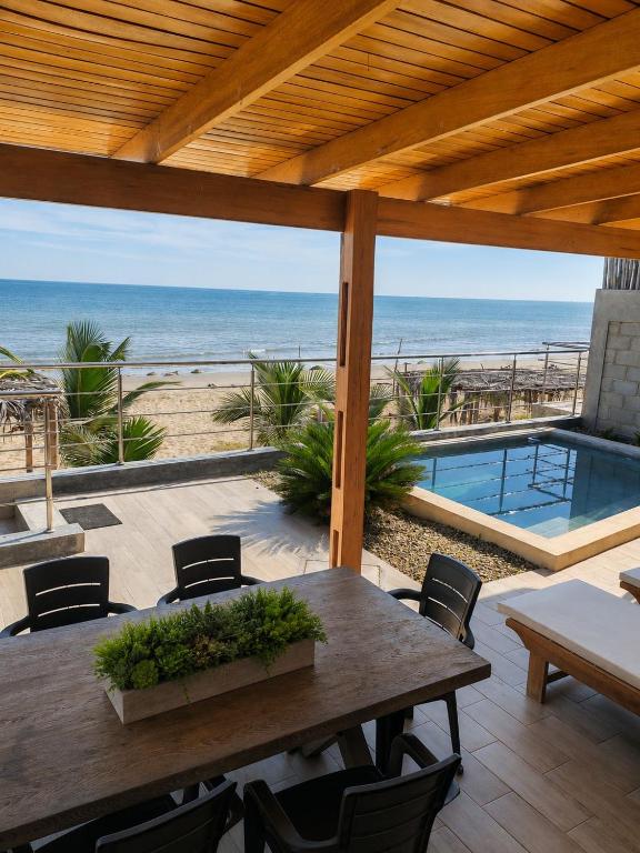 a patio with a table and a view of the beach at La Casa de David in Zorritos
