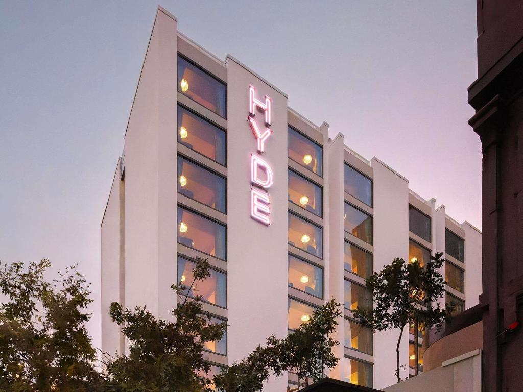 ein hohes weißes Gebäude mit einer Leuchtreklame darauf in der Unterkunft Hyde Perth in Perth
