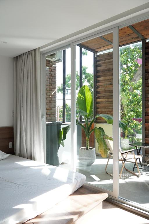 a bedroom with a bed and a window with a plant at 389 Hz Homestay in Danang