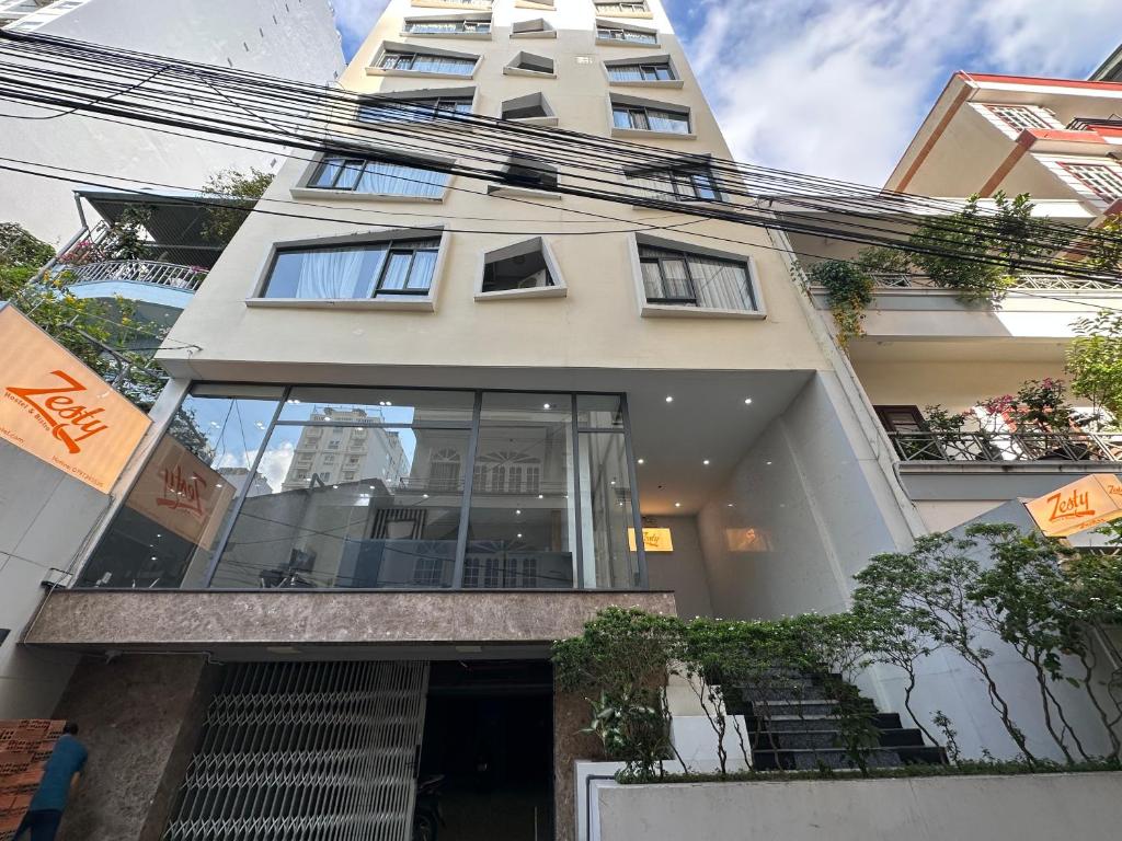 a large white building with glass windows at Zesty Hostel & Bistro in Nha Trang