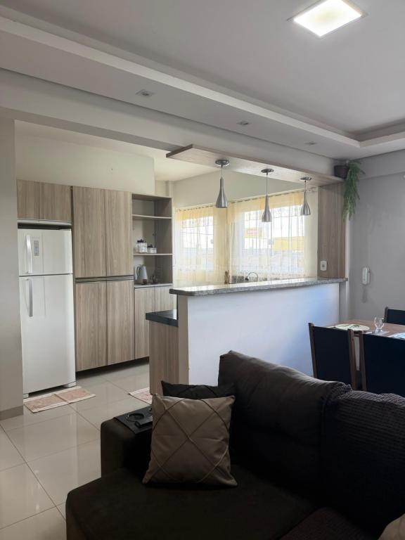 a living room with a couch and a kitchen at Apartamento completo in Nova Mutum