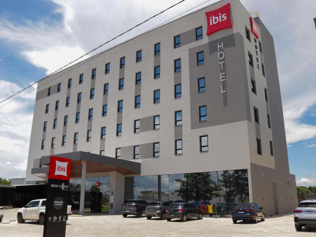 a hotel with cars parked in front of it at ibis Primavera do Leste in Primavera do Leste