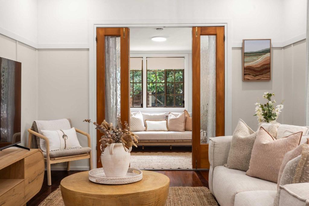 a living room with a couch and a table at Treehaven House & Cottage - Maleny Retreat in Maleny