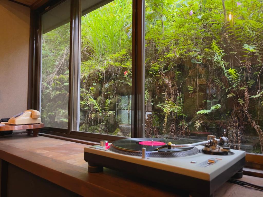 a room with a large window with a tub in front at Homestay HANIHOHETO in Ena