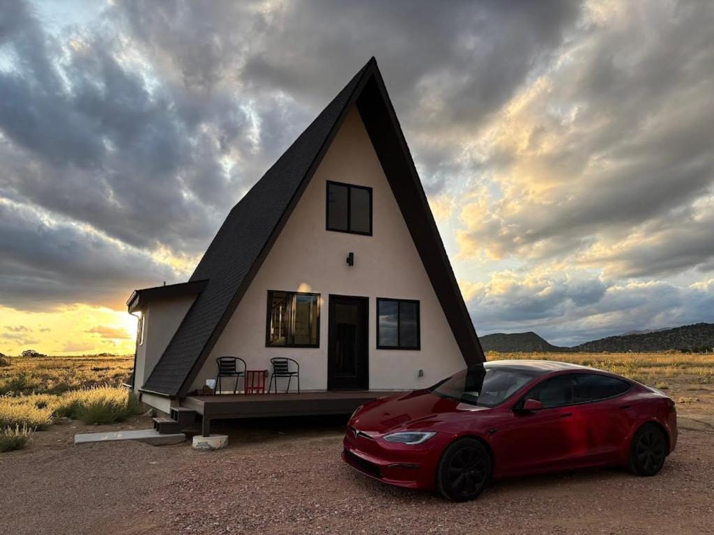 a red car parked in front of a small house at Observer Ranch Campground & Learning Center in Penrose
