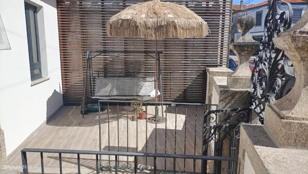 a patio with a table and an umbrella at Casa Bisavós de Coelhosa in Vale de Cambra